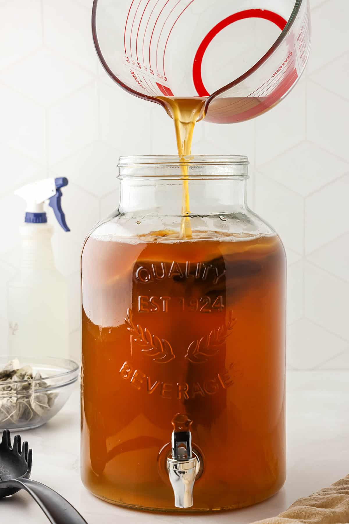 Kombucha pouring into a wide mouth gallon jar. 