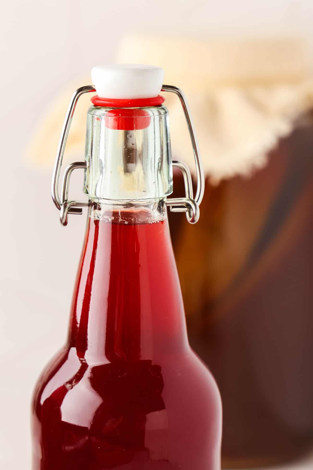 A close up of hibiscus kombucha in a bottle.
