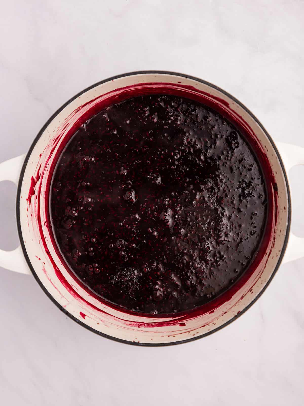 Cooked blackberry jam in a pot, top view. 