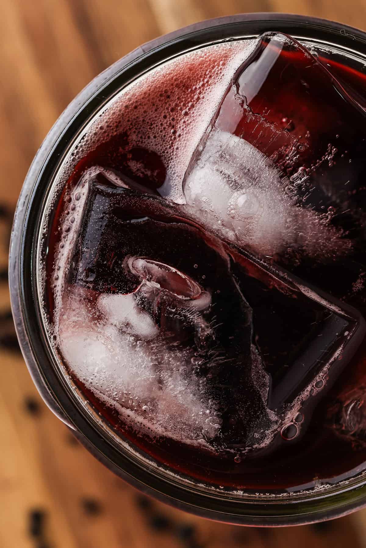 Elderberry kombucha on ice on a wood cutting board, top view. 