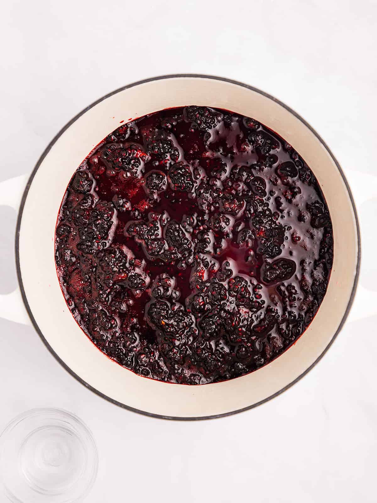 Mashed blackberries in a pot, top view. 