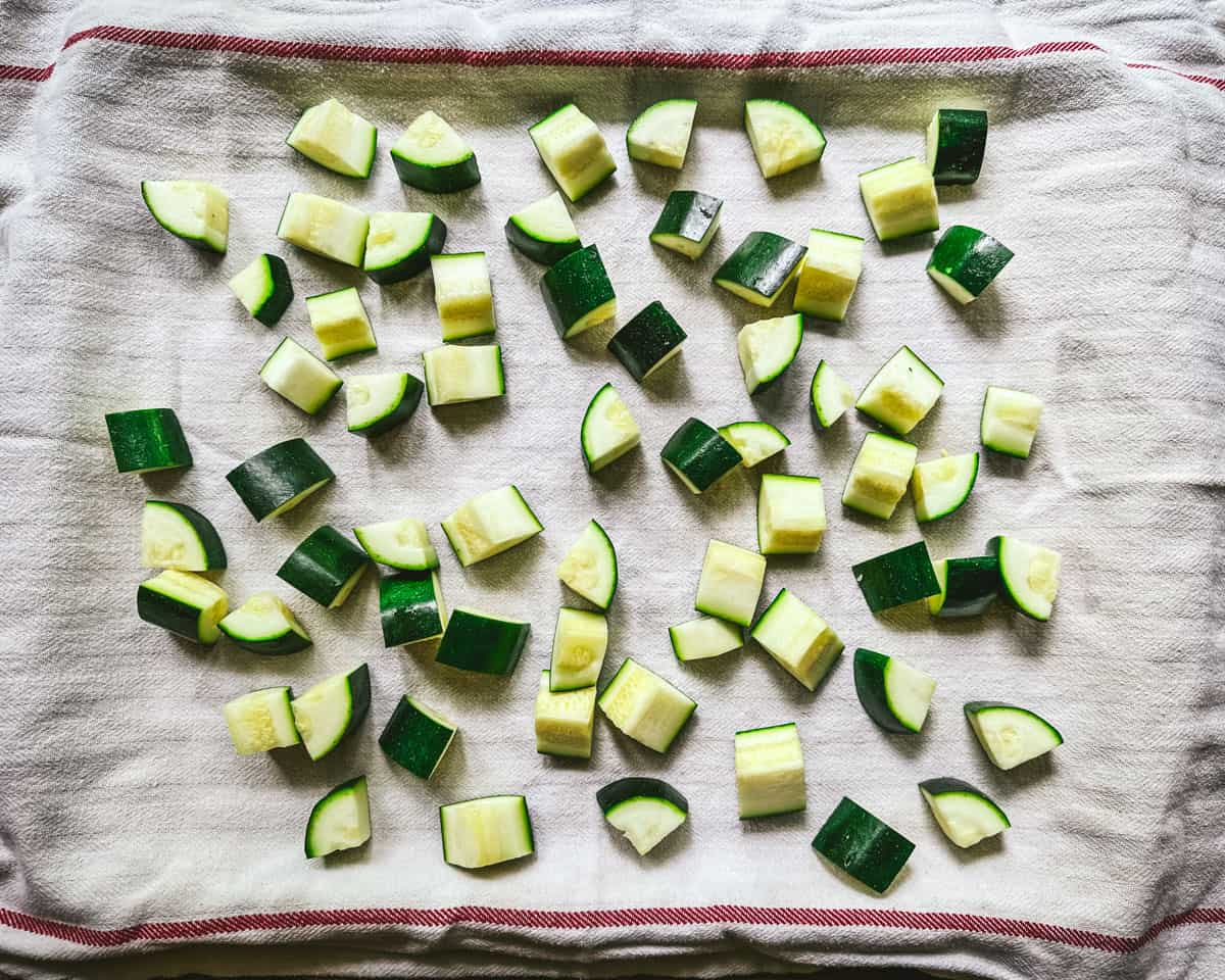 Steamed zucchini pieces cooking on a towel, top view. 