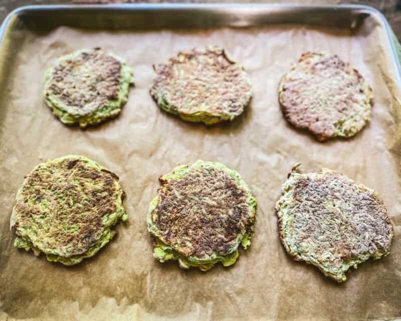 Zucchini pancakes frozen in one layer on a pan.