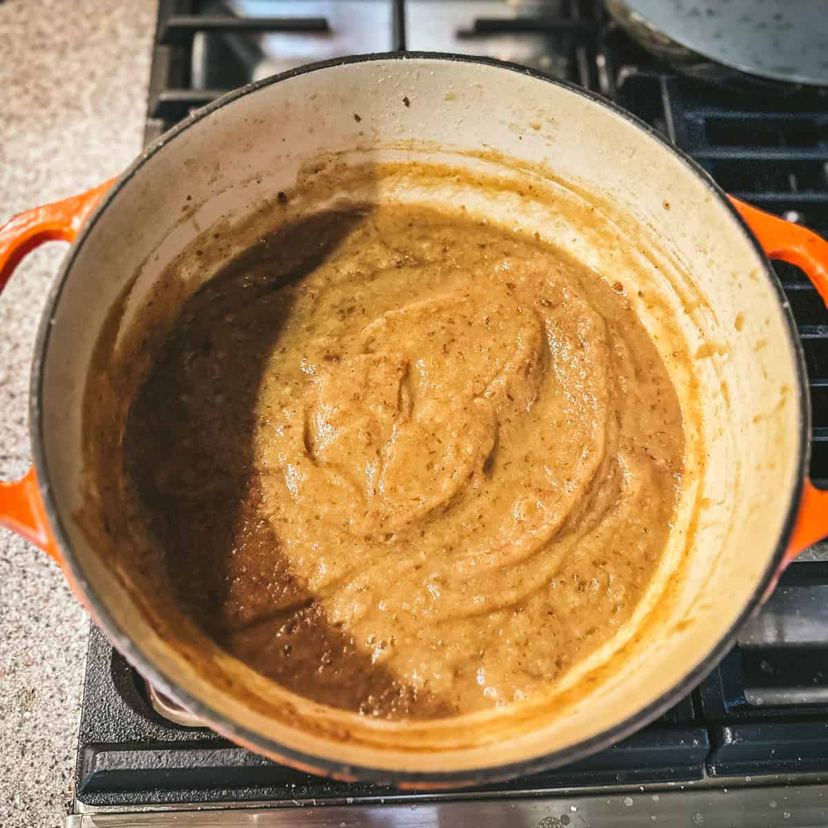 Pear butter simmering in the pot with spices, top view. 