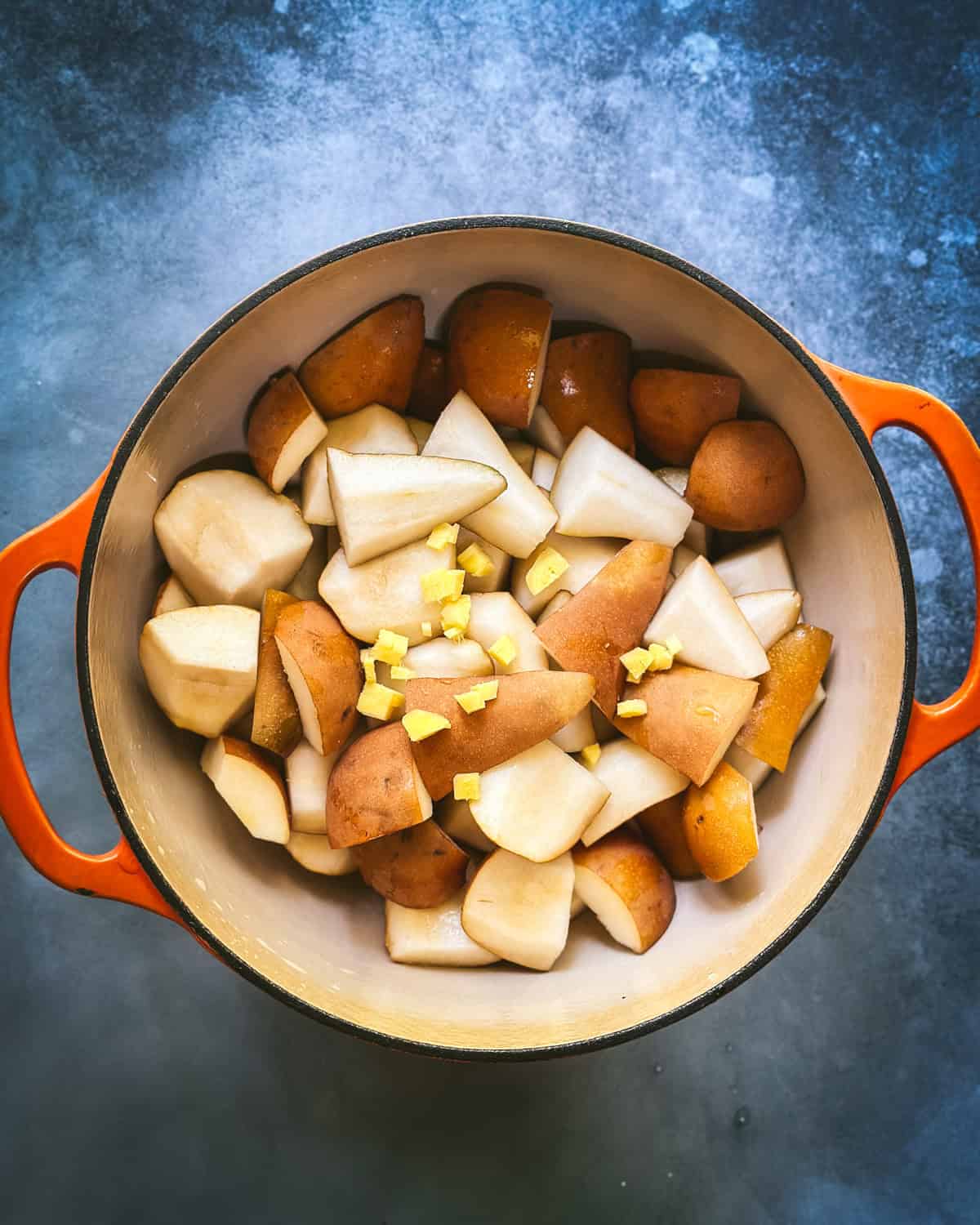 A pot with chopped pears and minced ginger in it. 