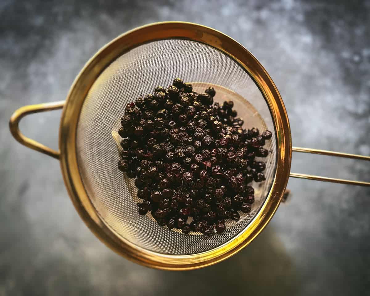 Reserved aronia berries in a mesh strainer. 