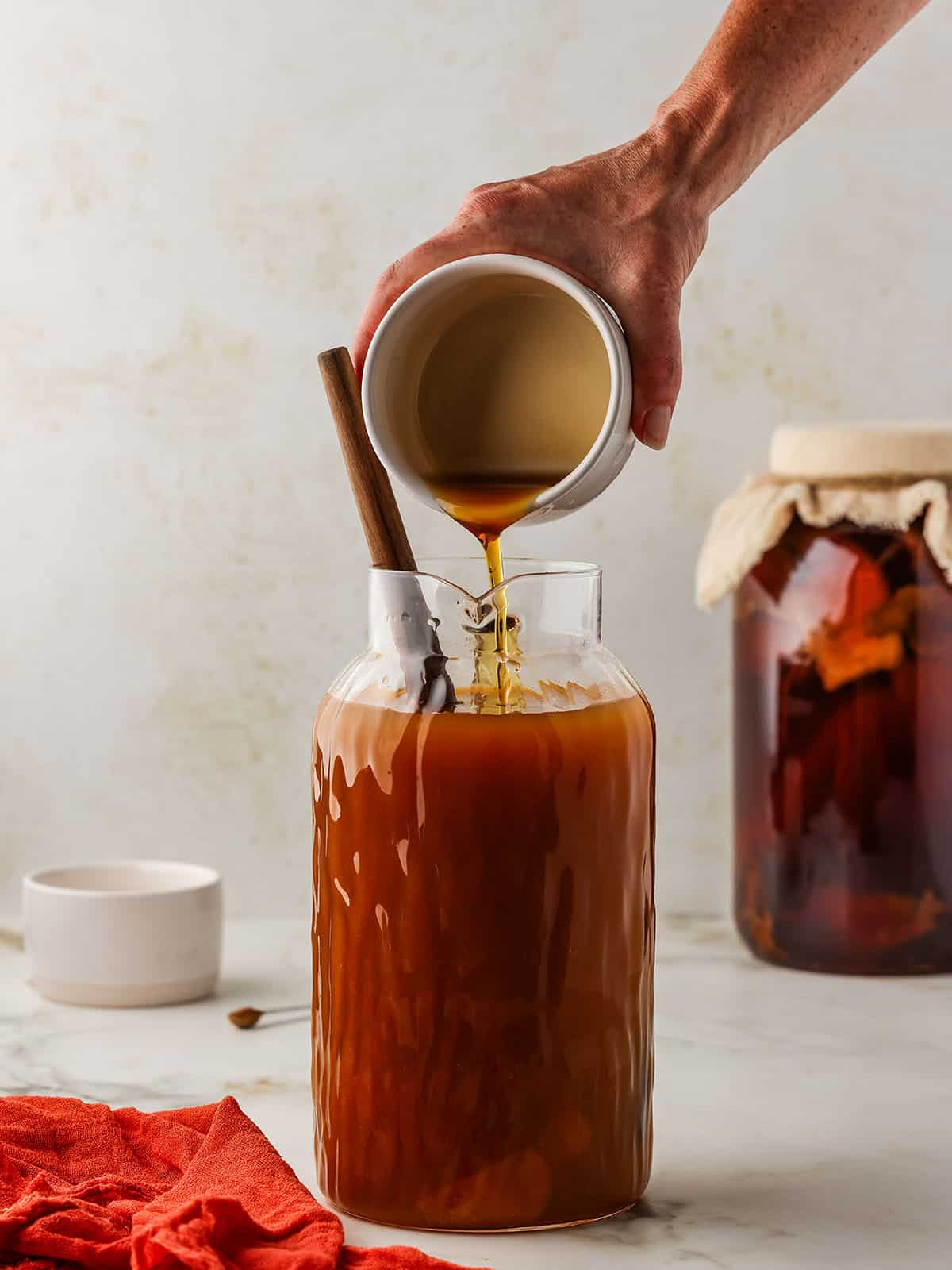 Maple syrup pouring into the pumpkin kombucha. 