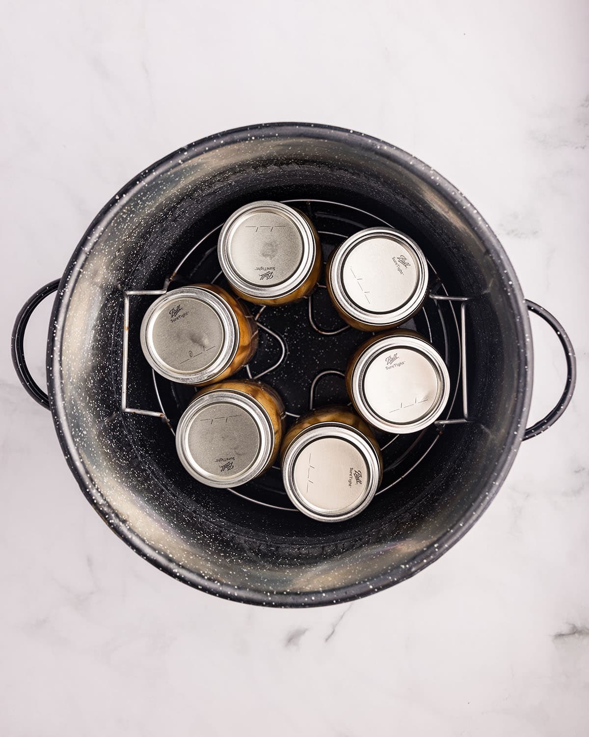 A water bath canner with jars in it, top view. 