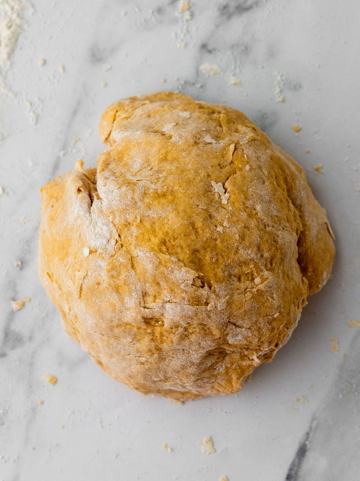 Pumpkin dough on a white surface ready to knead. 