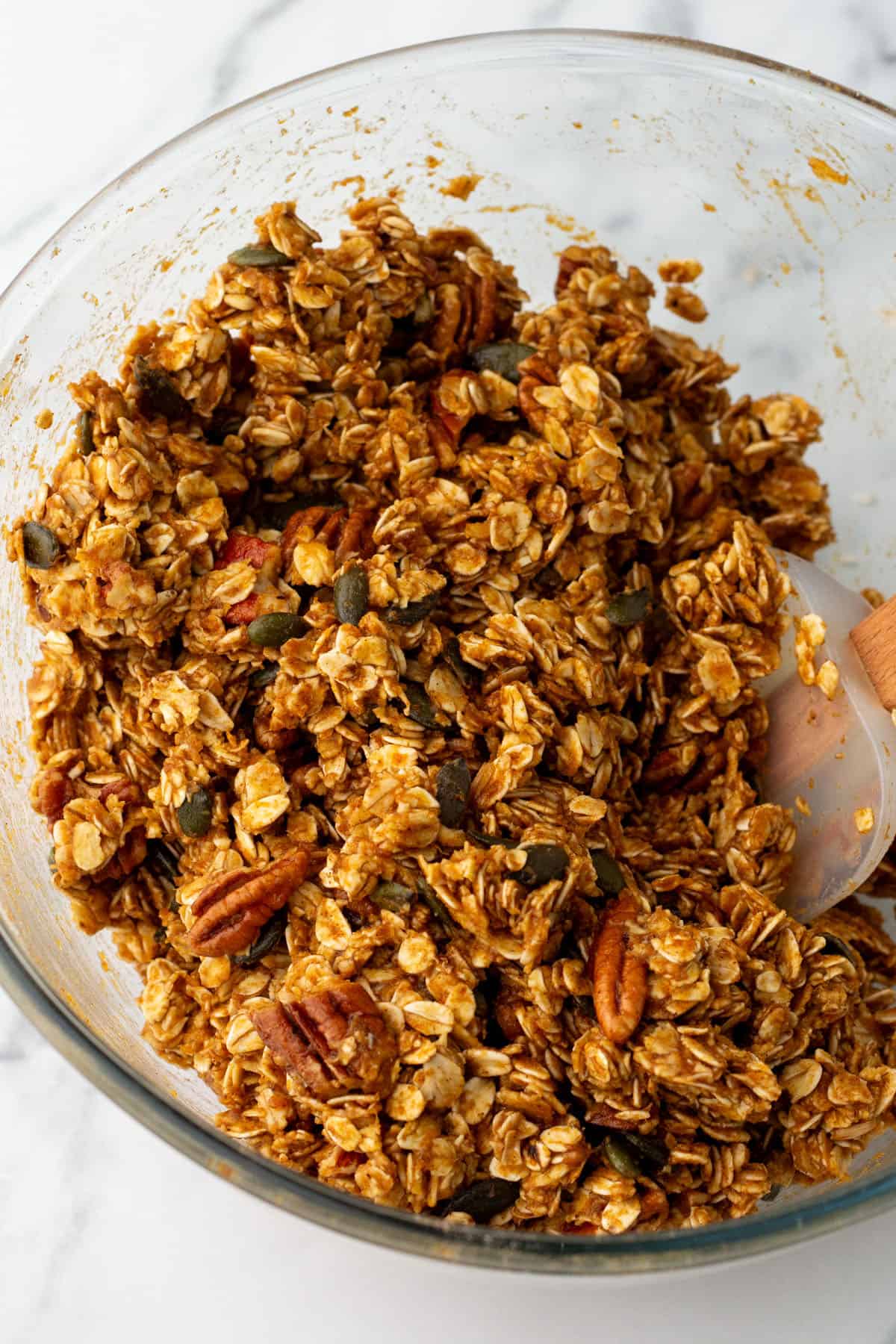 Pumpkin granola mixed in a mixing bowl, top view. 