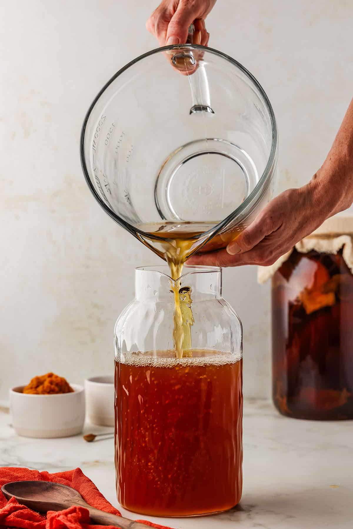 Kombucha pouring into a large jar. 