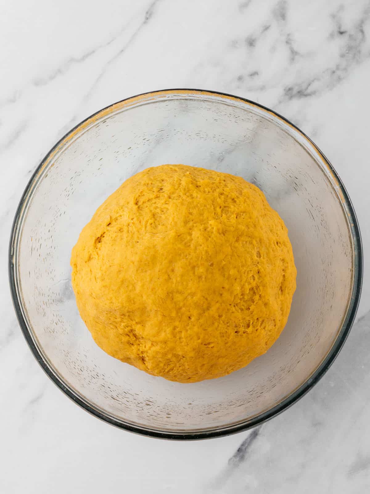 Pumpkin dough in a bowl ready to rise, top view. 