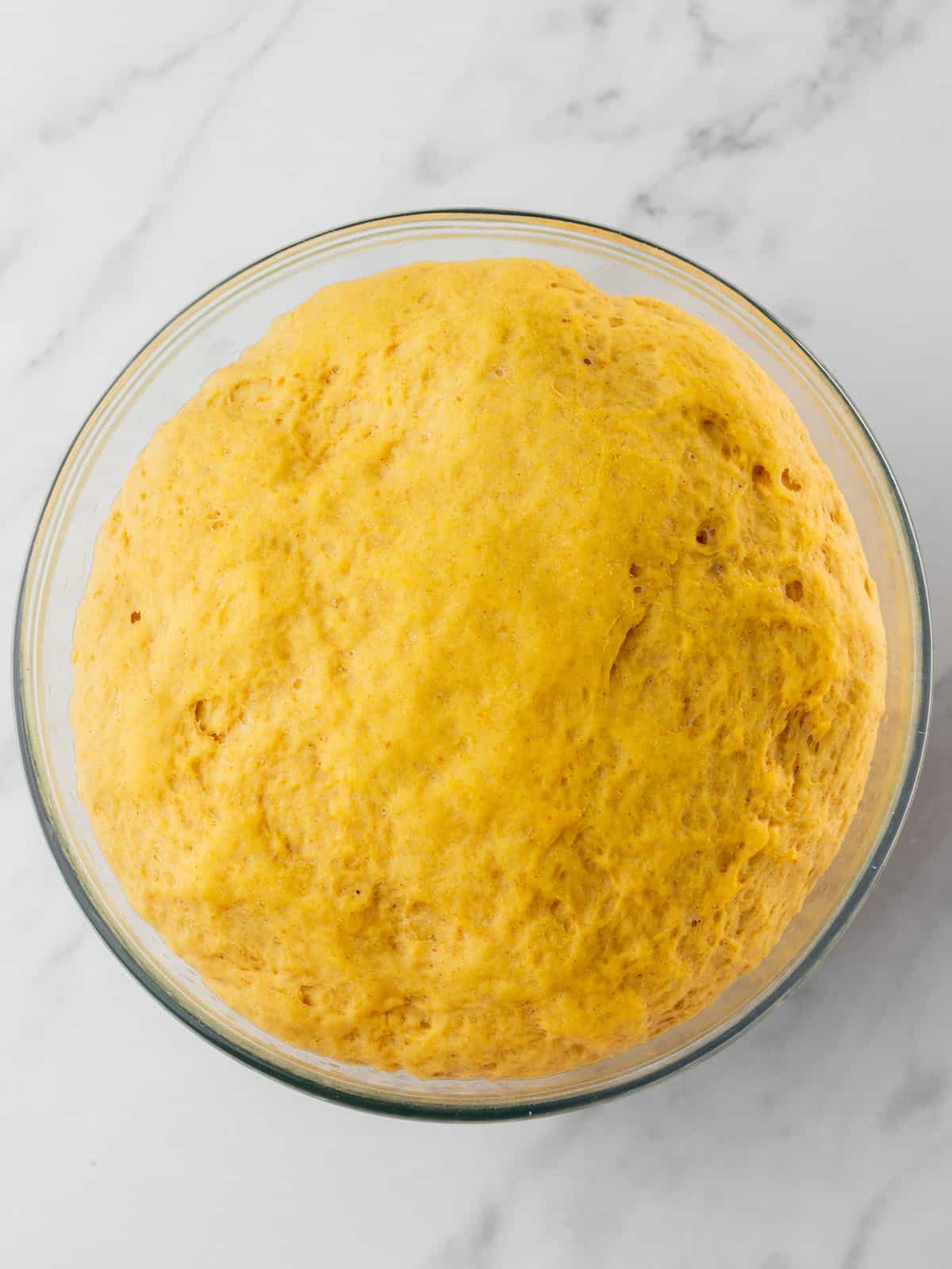 Pumpkin dough risen in a bowl, top view. 