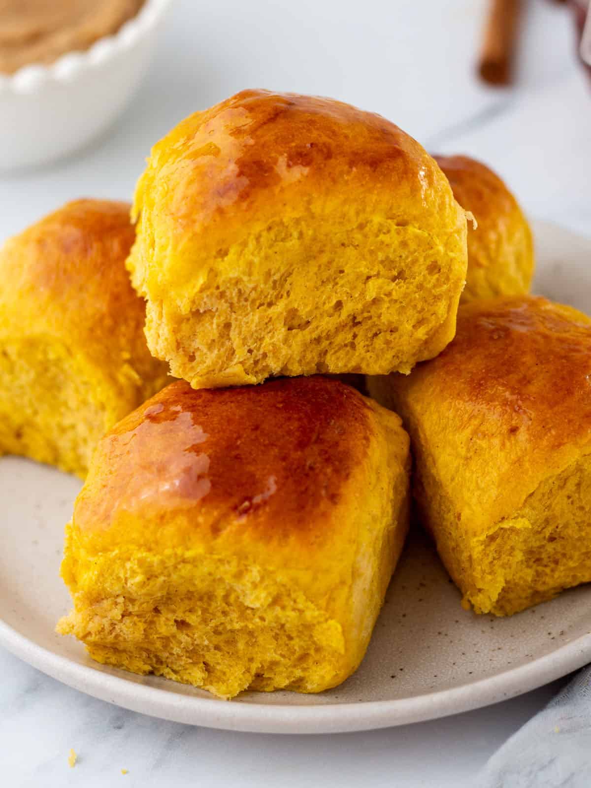 A plate of pumpkin dinner rolls. 