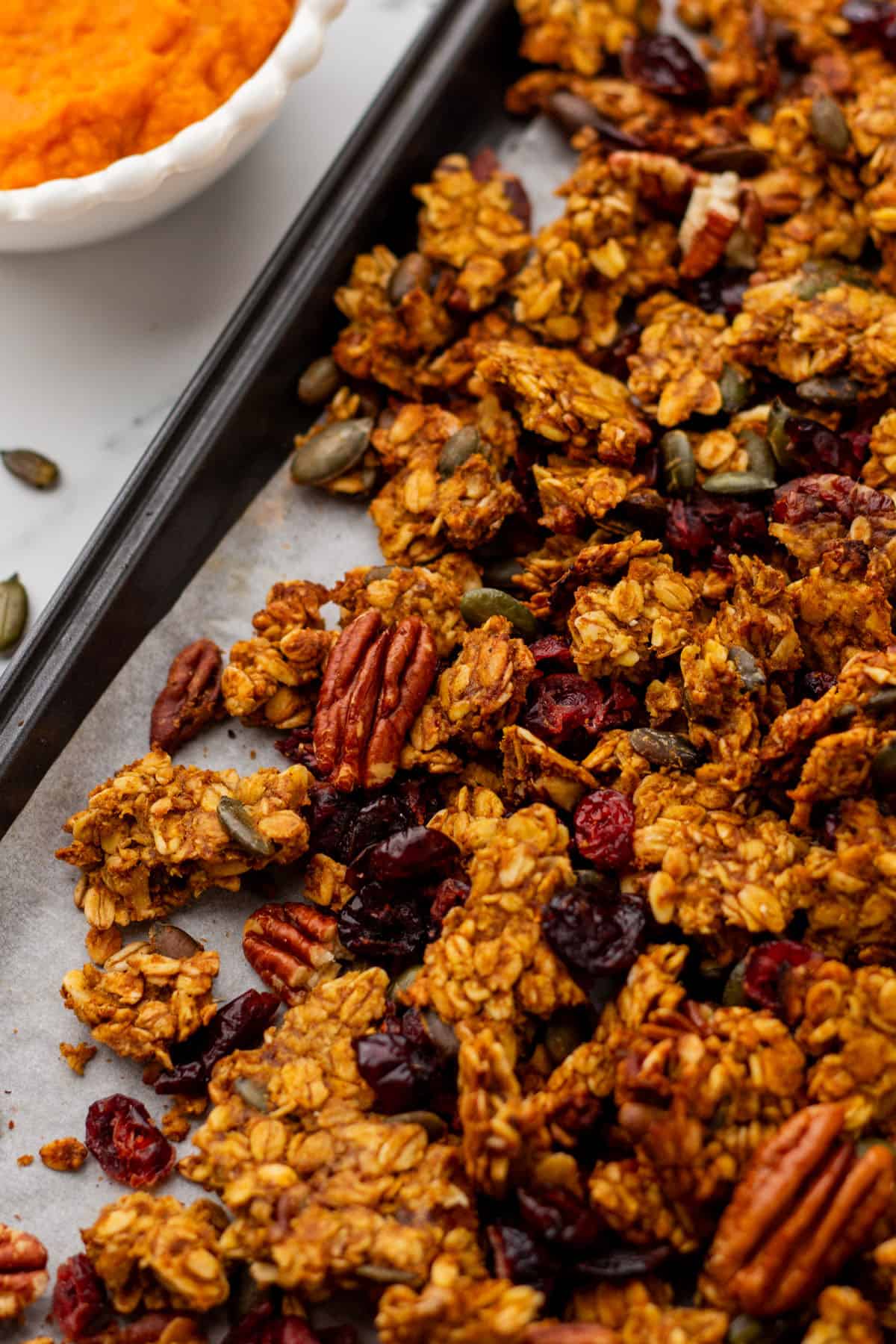 Pumpkin granola with pecans on a baking sheet, close up. 