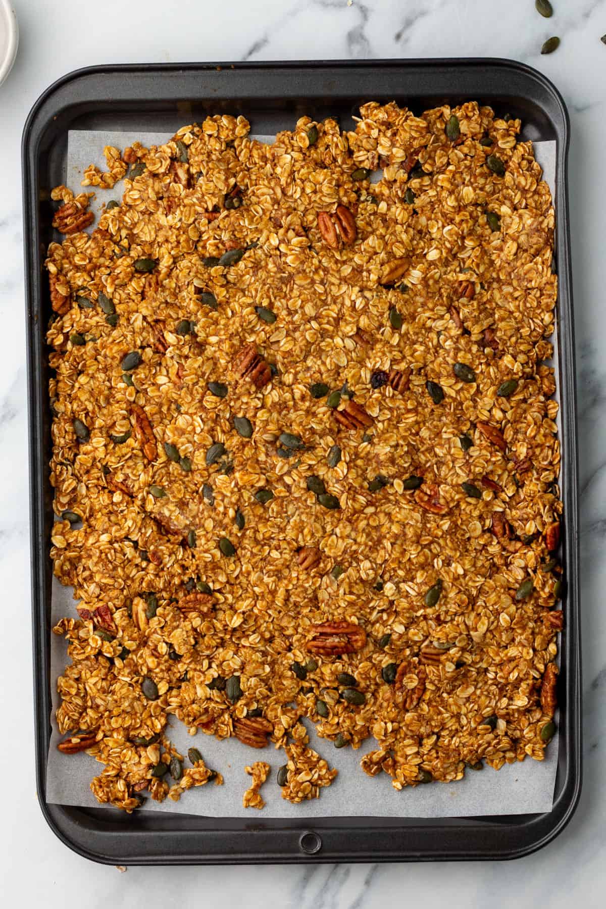 Granola spread onto a sheet pan. Top view. 