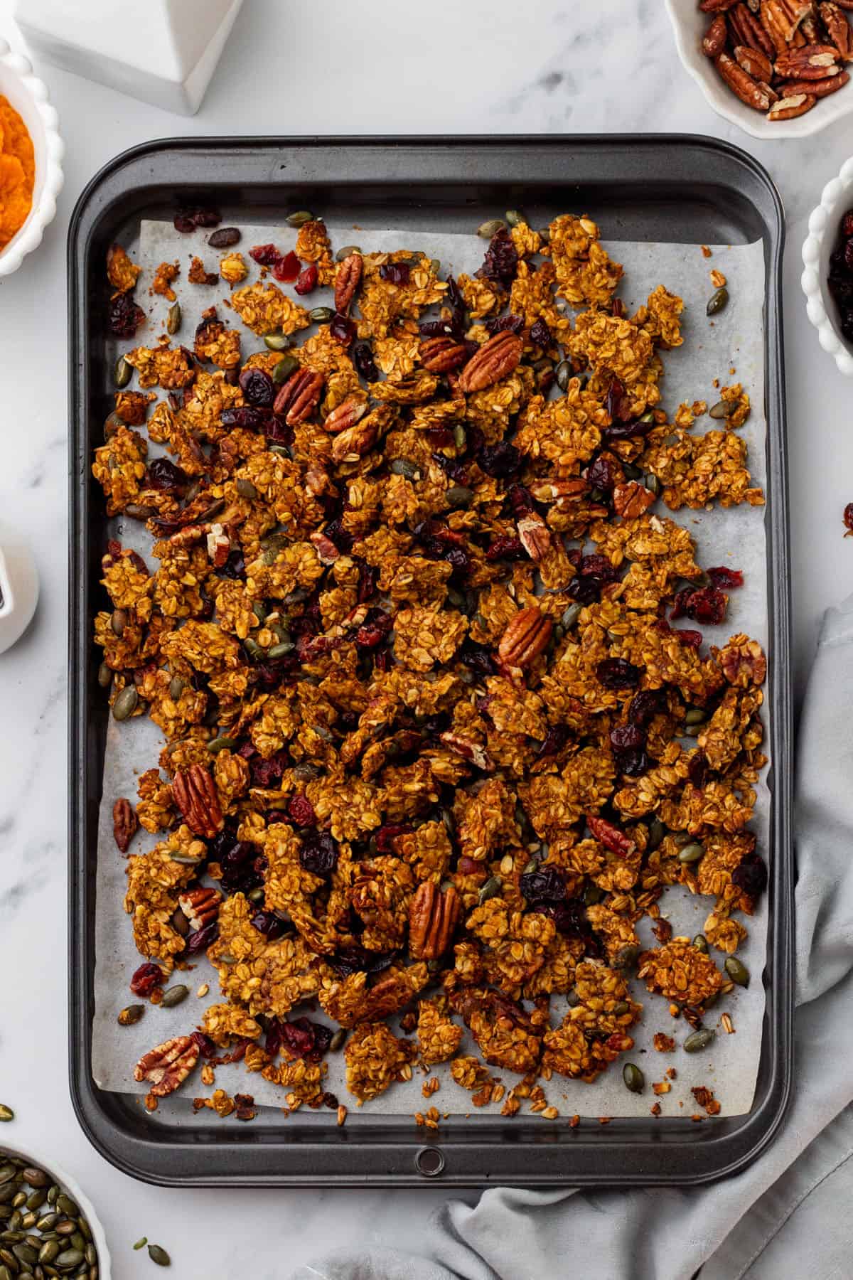 Granola with dried cranberries on a baking sheet, top view. 