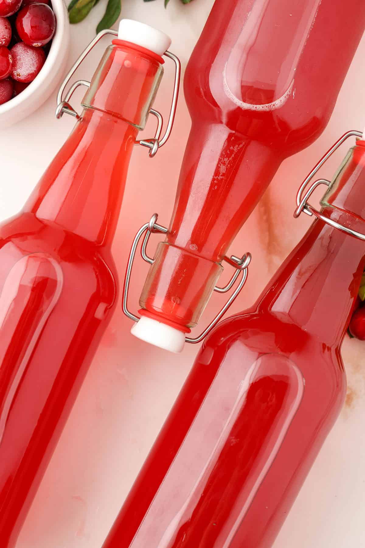 Cranberry kombucha in bottles on their side.